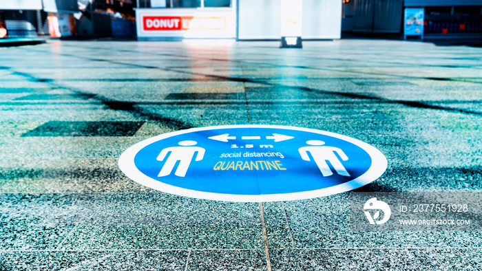 The blue sticker on the floor in shopping centrum as a practicing of the Social Distance during the 