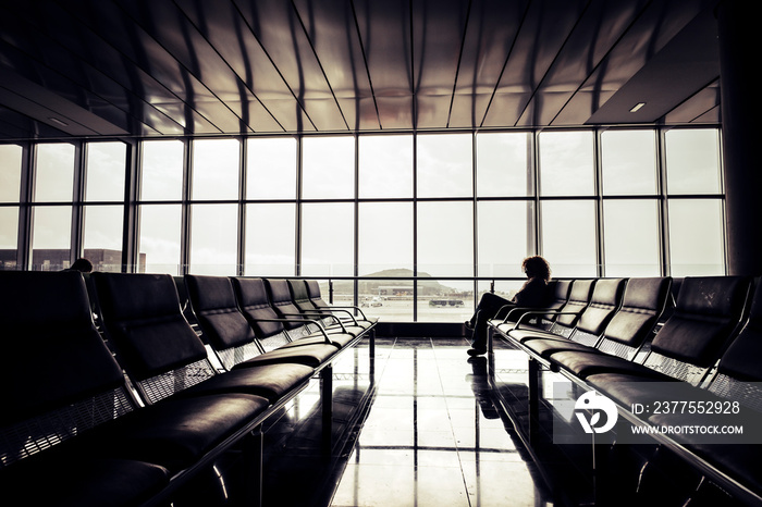 Cancel delay flight at the airport concept with alone traveler waiting sit down on the seats - trave