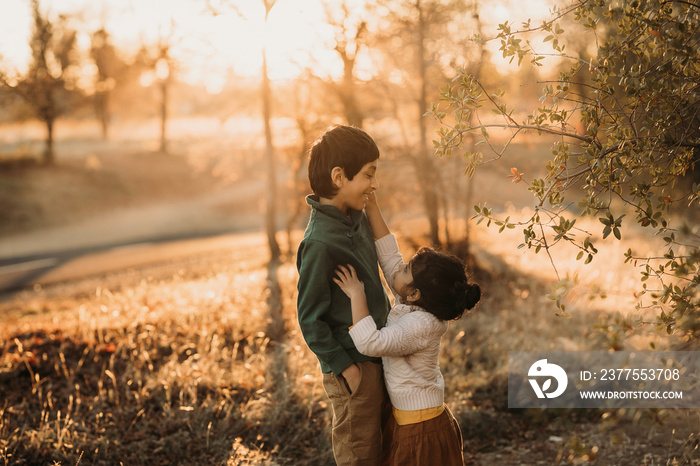 Brother and sister outdoors at a trail hugging each other