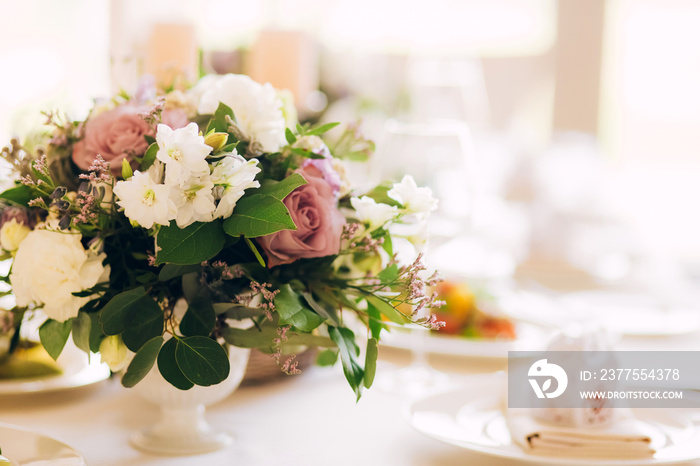 Gorgeous luxury wedding table arrangement, floral centerpiece close up. The table is served with cut