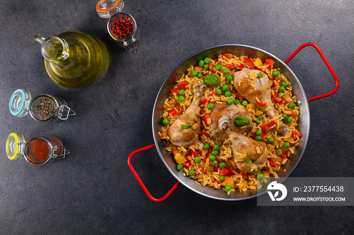 Arroz con pollo. Baked pieces of chicken with bone, rice with paprika and peas.
