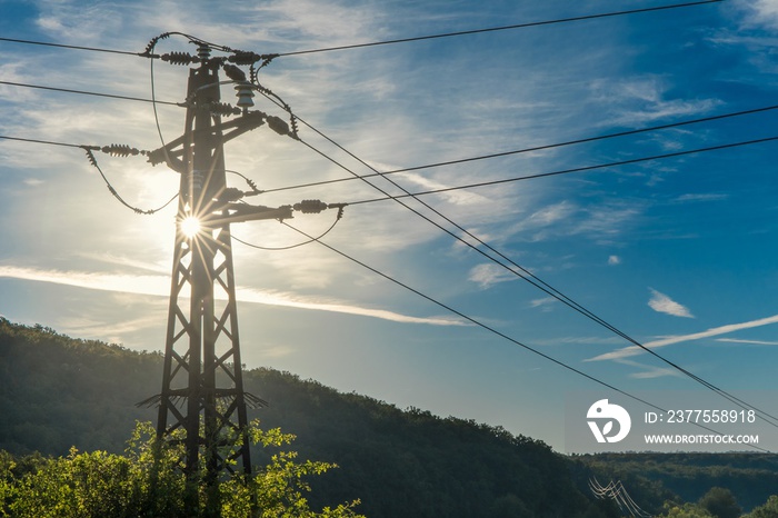 Silhouette of an electric pole against the sun. Energy concept. Ecological energy. Old rusty electri