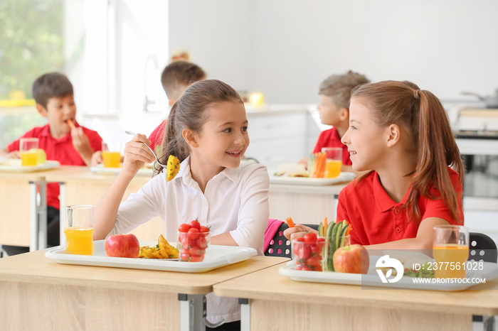 Pupils having healthy lunch in classroom