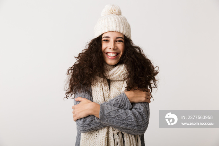 Cheerful young woman wearing winter scarf standing