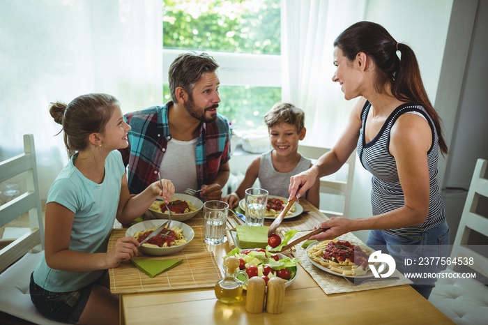 Woman serving meal to her family