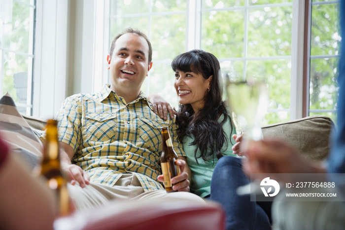 Couple enjoying drinks at home with friends