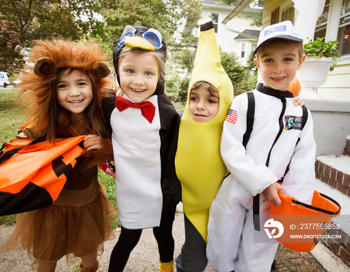 Portrait of smiling friends in Halloween costume standing outdoors