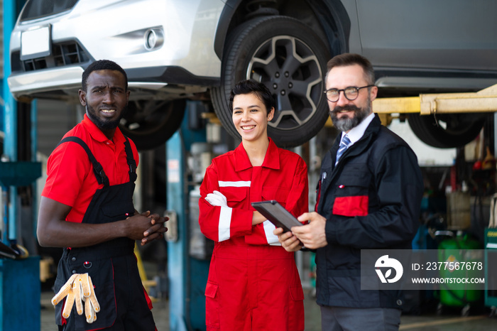 Team of mechanics discussing at the repair garage. Professional Expertise mechanic team working in a