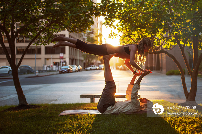 Young couple doing yoga in park