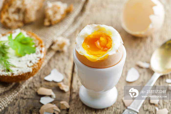 完美的煮软鸡蛋、面包和黄油，在餐桌上享用美味健康的早餐。传统ho