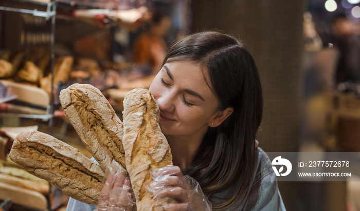 Young woman in supermarket with fresh bread .