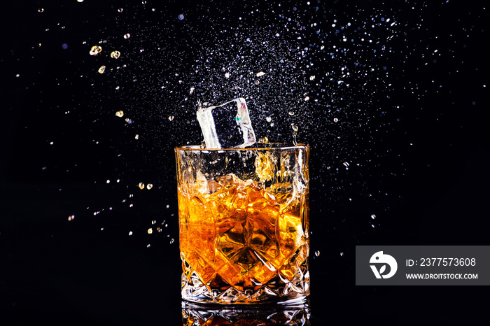 whiskey with splash on black background, brandy in a glass