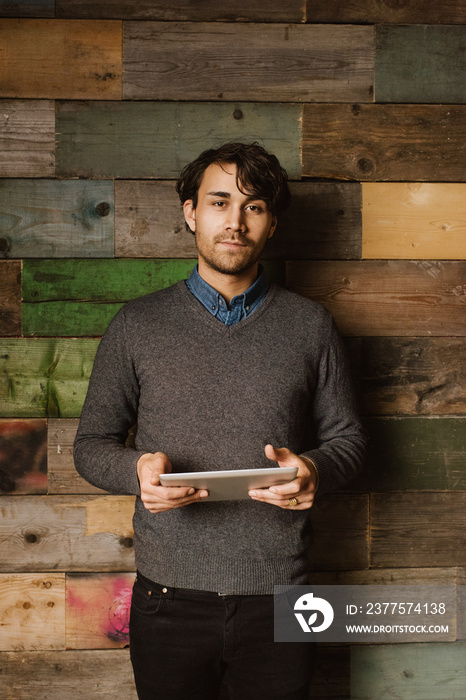 Confident young man holding a digital tablet in office