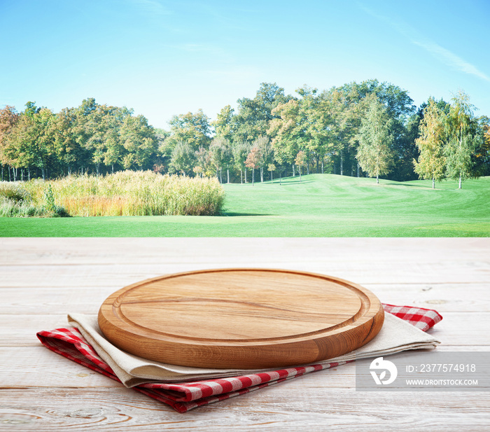 Napkin and board for pizza on wooden desk. Summer Landscape.