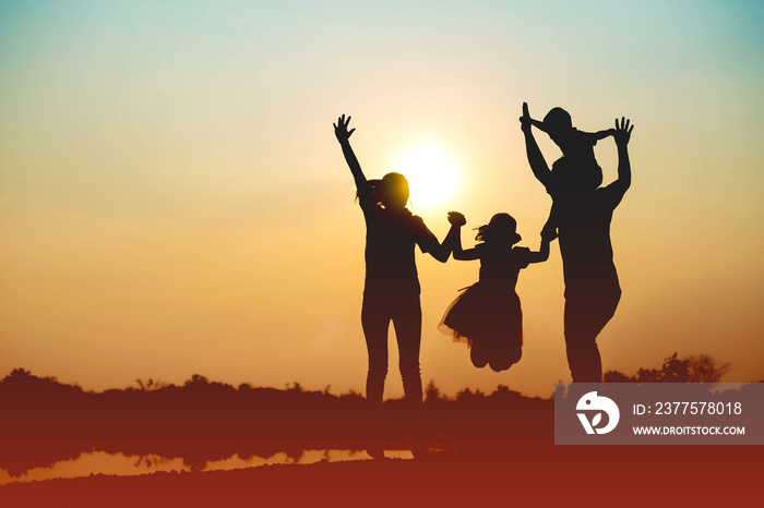 Silhouette of a family comprising a father, mother and two children happy family the sunset.Concept 