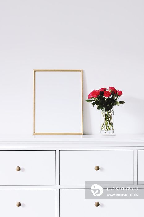 白色家具上的金色水平框架和一束玫瑰花，豪华家居装饰和设计
