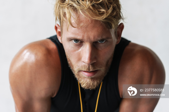 Photo closeup of athletic young sportsman looking at camera