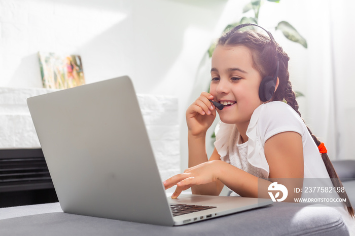 Little girl kid studen studying online class with laptop at home, New normal. Covid-19 coronavirus. 