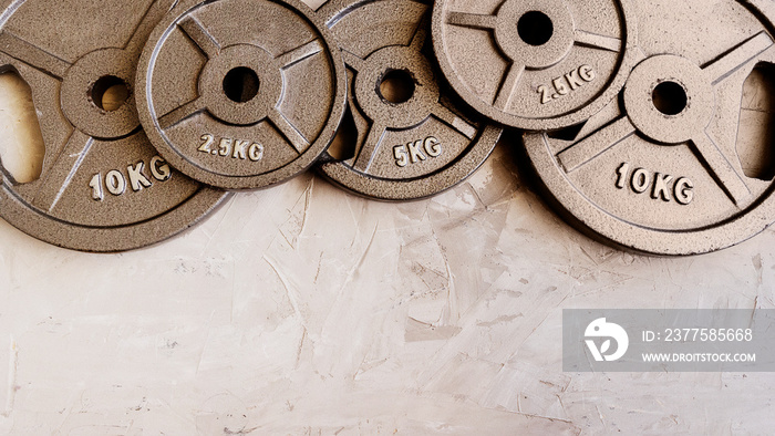 Weight plates for barbell or dumbbells in cement floor in gym. Equipment  for weight training and  b