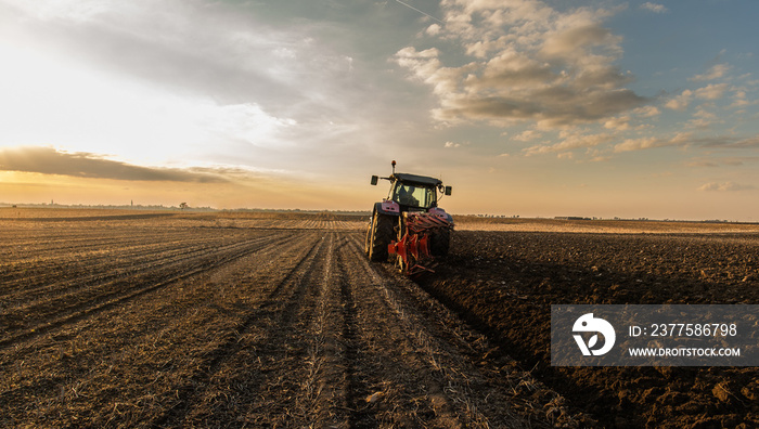 Tractor on the field during sunset.