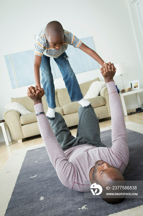 Son standing on fathers knees