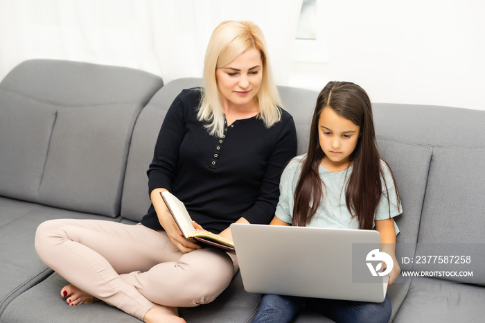 family looking at silver laptop together, mother and daughter online