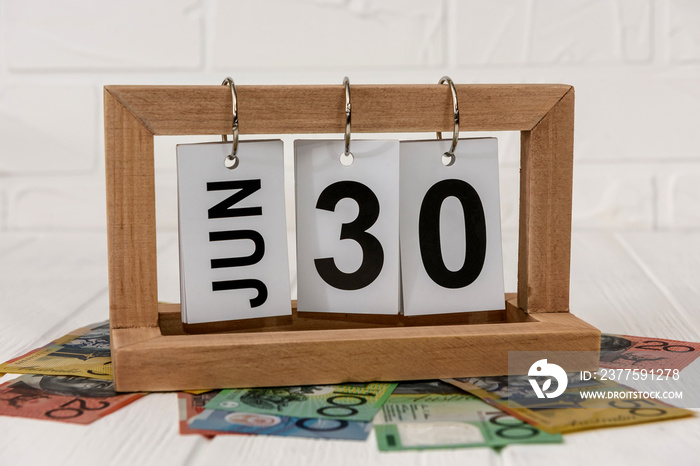 Wooden calendar with australian dollar banknotes closeup