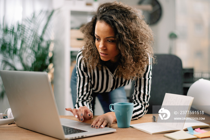 Young businesswoman in office. African beautiful woman using lap top.