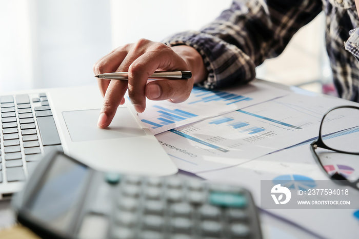 Business man or accountant working with laptop computer for calculating financial accouting at offic