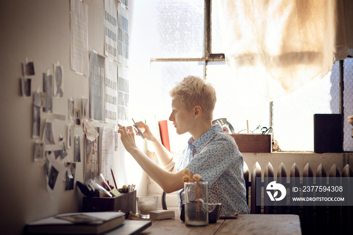 Young woman hanging pictures on wall