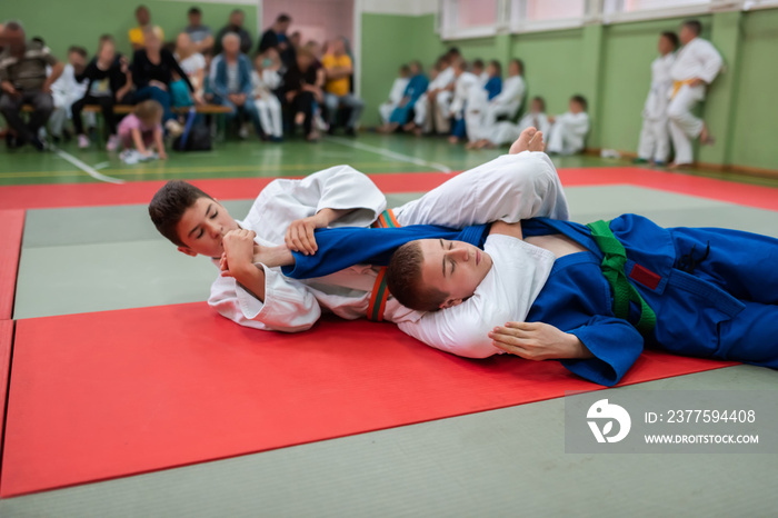 两名柔道选手在格斗俱乐部练习武术时展示了技术技巧。两人很合拍