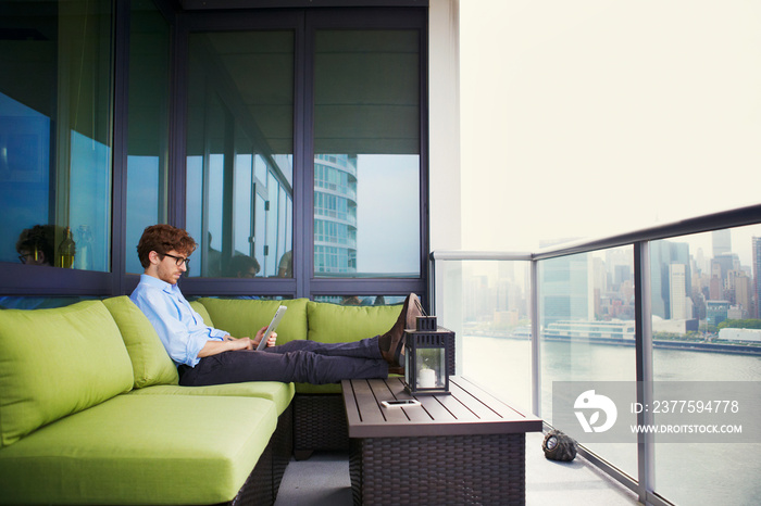 Side view of businessman using digital tablet on sofa