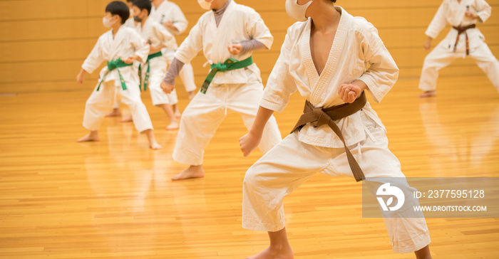 教室で空手を練習している学生たちの姿