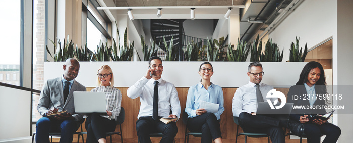 Smiling group of diverse businesspeople waiting in an office rec