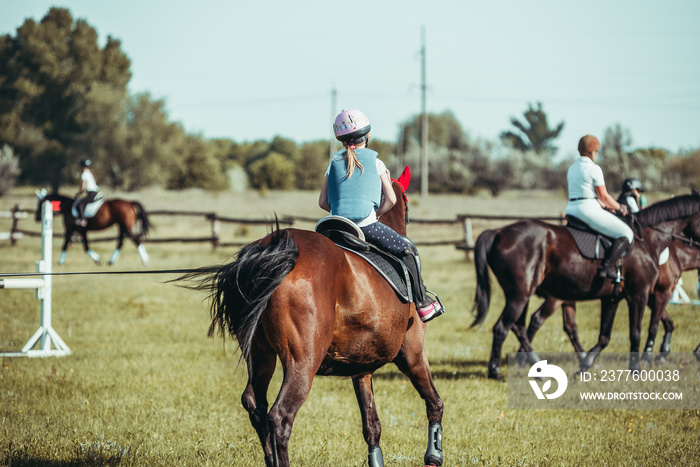 A little girl is learning to ride a horse.