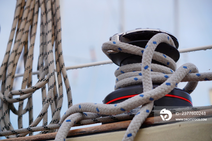 A self-tailing winch of a sailing boat with rope over it.