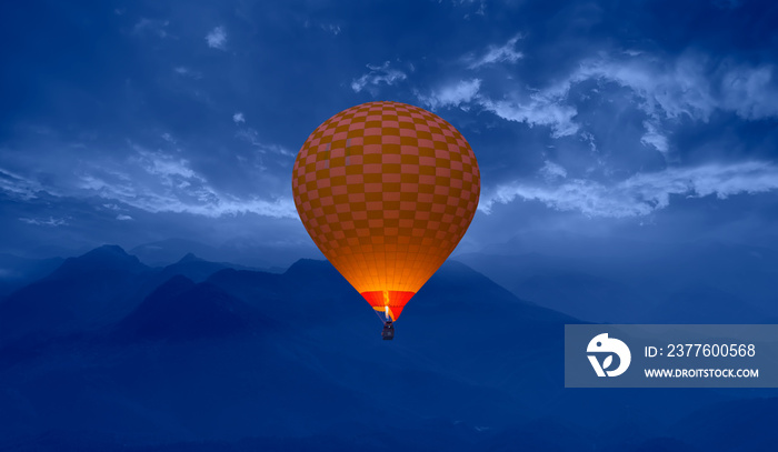 Hot air balloon fly over blue mountains landscape at sunset