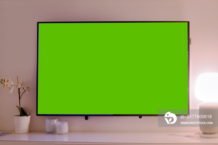 The TV is on the table, the green background on the TV.