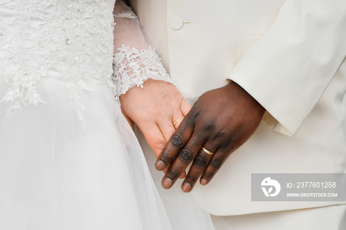 Causian and African couple holding hand with ring