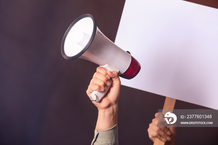 Protesting people with megaphone and placard on dark background