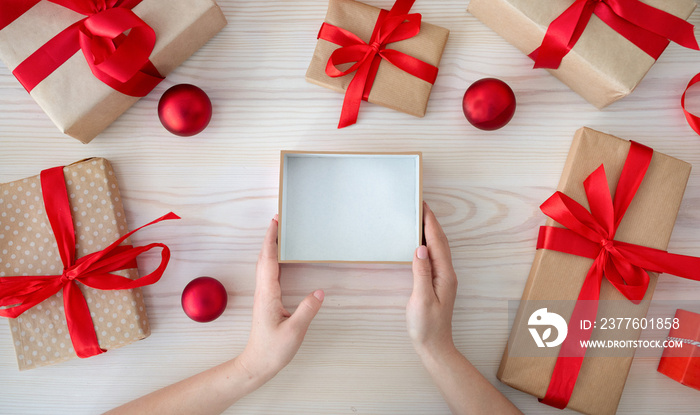 Christmas gift. Female hands holding empty craft gift box, preparing surprise for holiday, top view, copy space