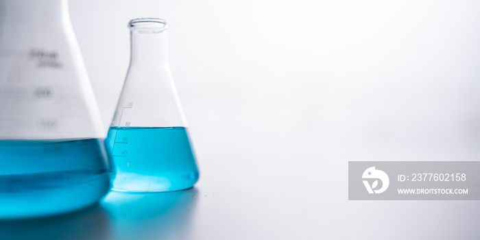 blue chemical liquid experiment in scientific glassware equipment in science medicine laboratory, chemistry or biology research discovery by using glass of test tube or beaker and flask