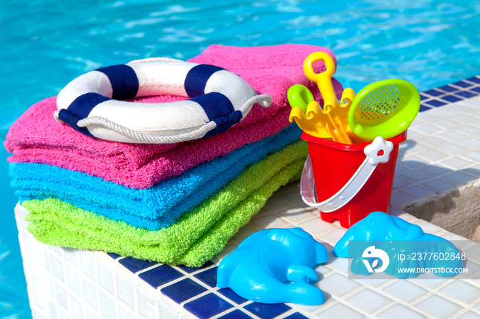 Towels and children toys near the swimming pool