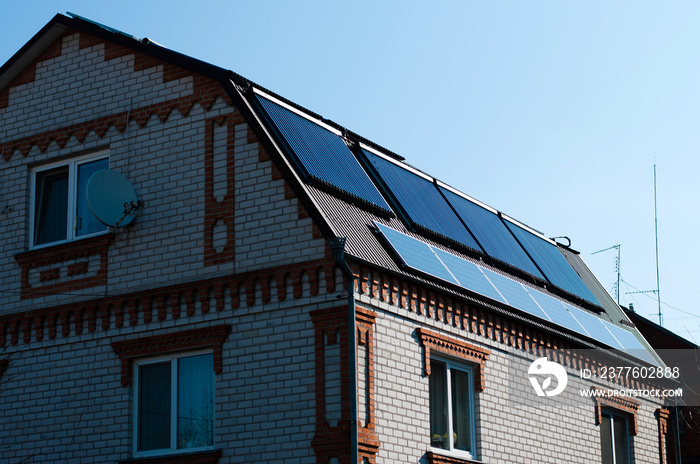 Solar panel system on house roof, sunny blue sky background.Blue solar panels.