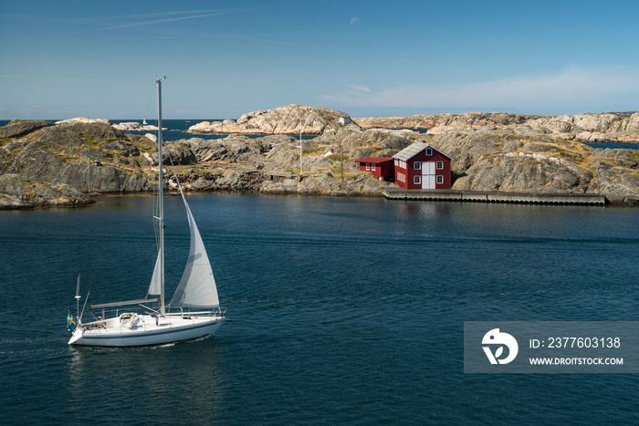 Sea landscape with sailboat and rocky coastline on the South of Sweden. Southern coastline of Sweden with view at sailing-ship and rocky islands.