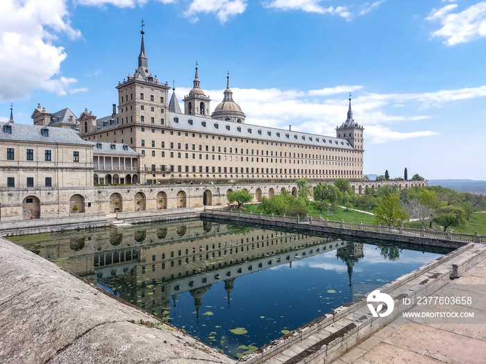 monastery of San Lorenzo de El Escorial with tourists strolling through its gardens and patios in Madrid