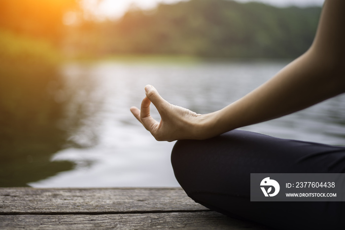 Close up hand. Woman do yoda outdoor. Woman exercising yoga at the nature background, select focus