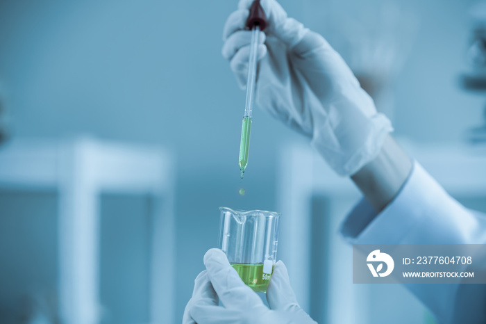 Scientist wearing uniform and glass holding test tube in laboratory research and development concept for industry or hospital