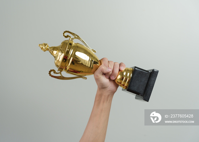 Close up man hands holding champion golden trophy isolated over background.