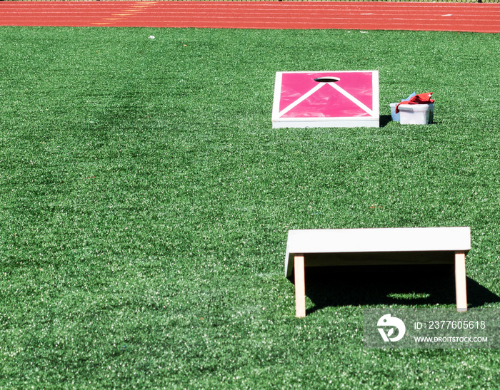 Corn hole game set up on turf field